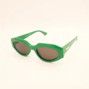 Groene ovale zonnebril met bruine glazen en gouden detail op de poot