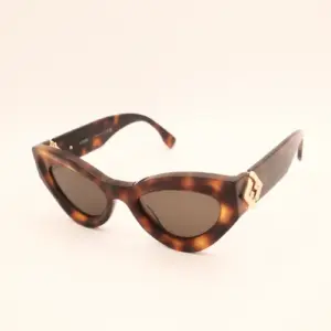 Cat-eye zonnebril met schildpadmotief en gouden details op lichte achtergrond