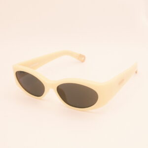 Beige cat-eye zonnebril met donkere glazen op lichtroze achtergrond